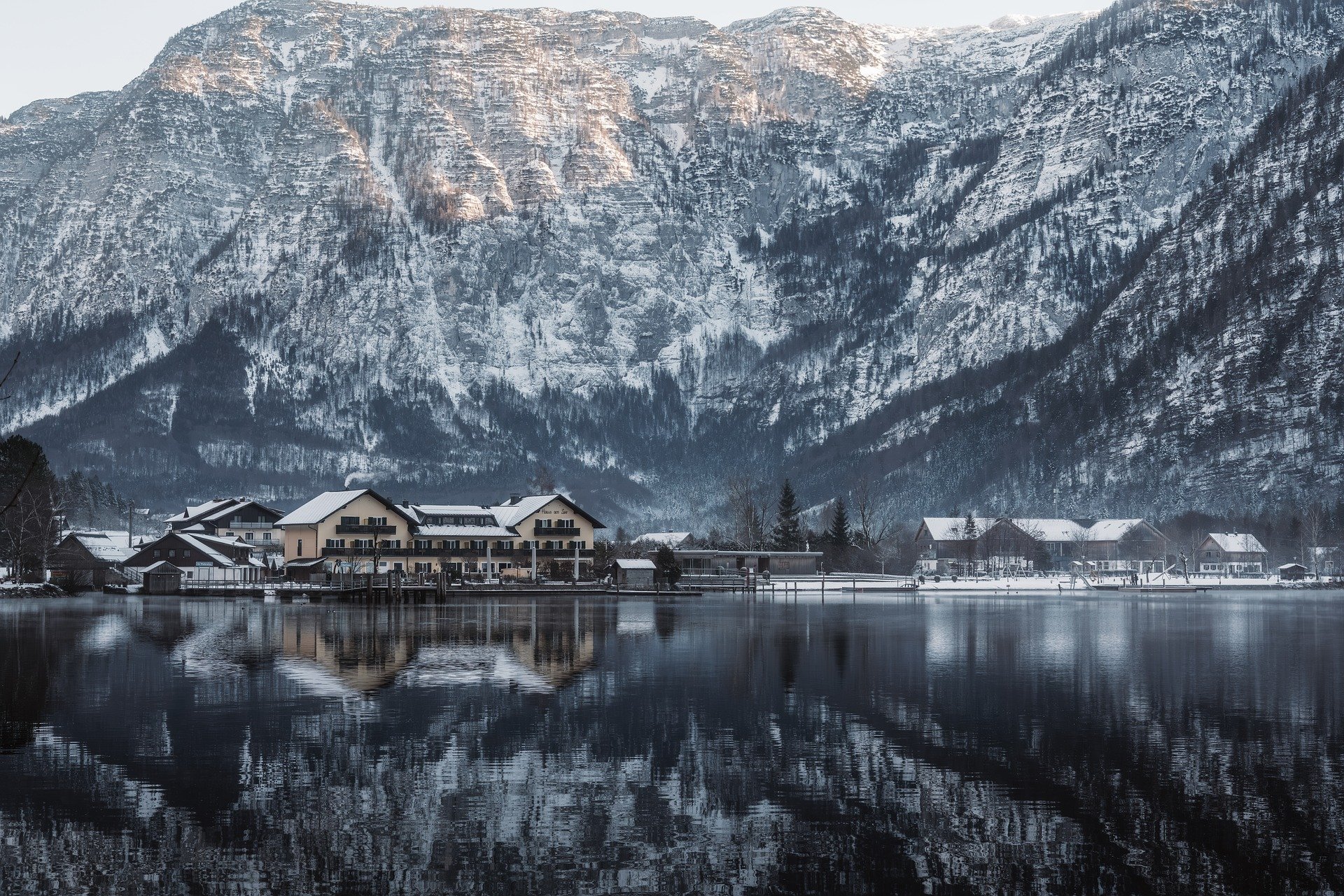 Village de montagne enneigé avec reflet sur un lac
