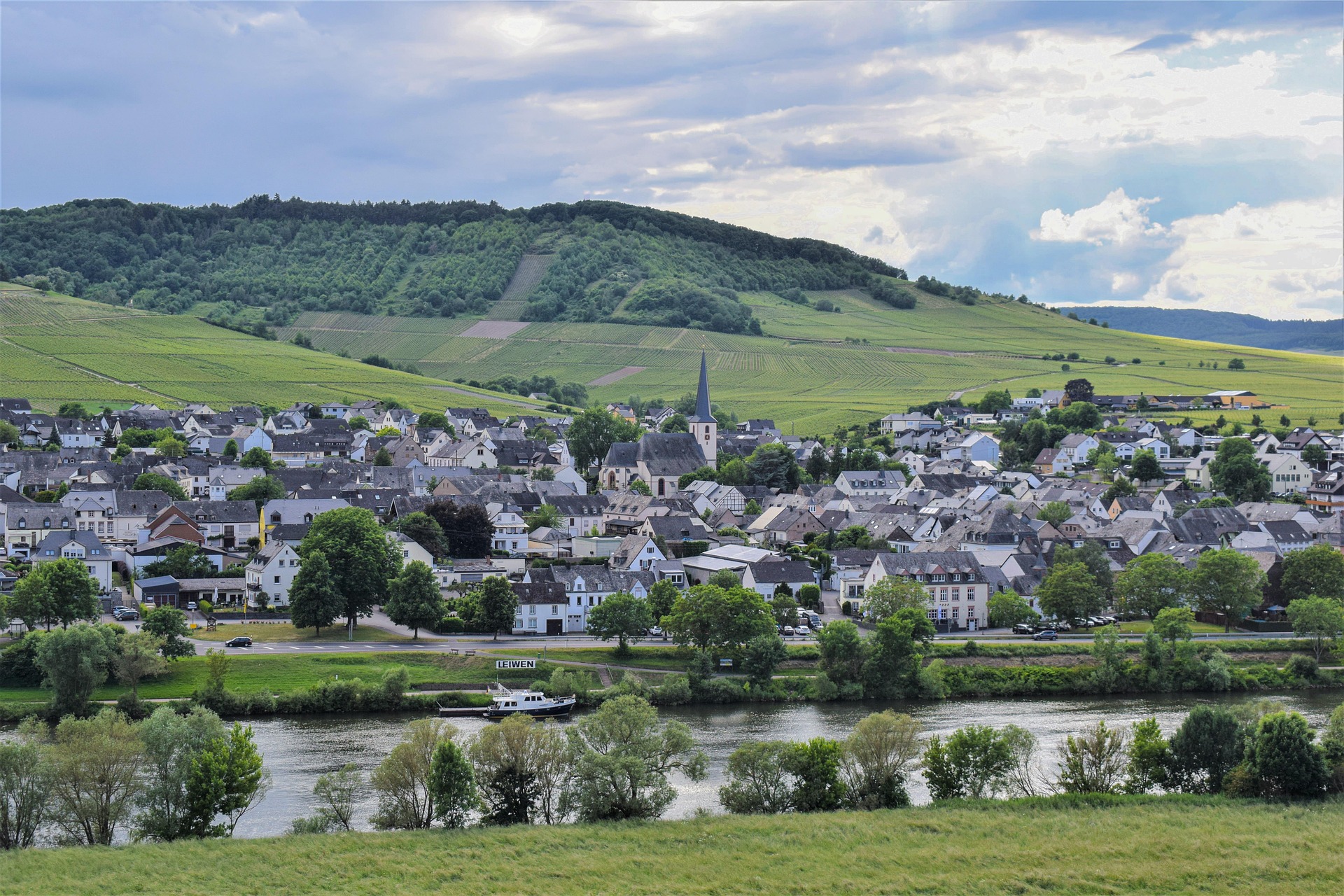 Village typique avec église et rivière en vallée montagneuse