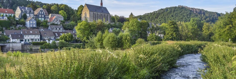 village de montagne avec rivière et église dans un cadre naturel