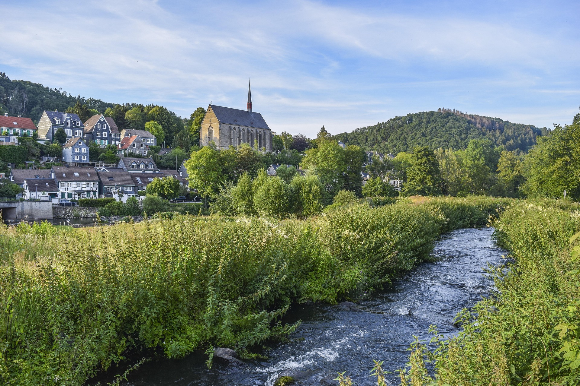 village de montagne avec rivière et église dans un cadre naturel