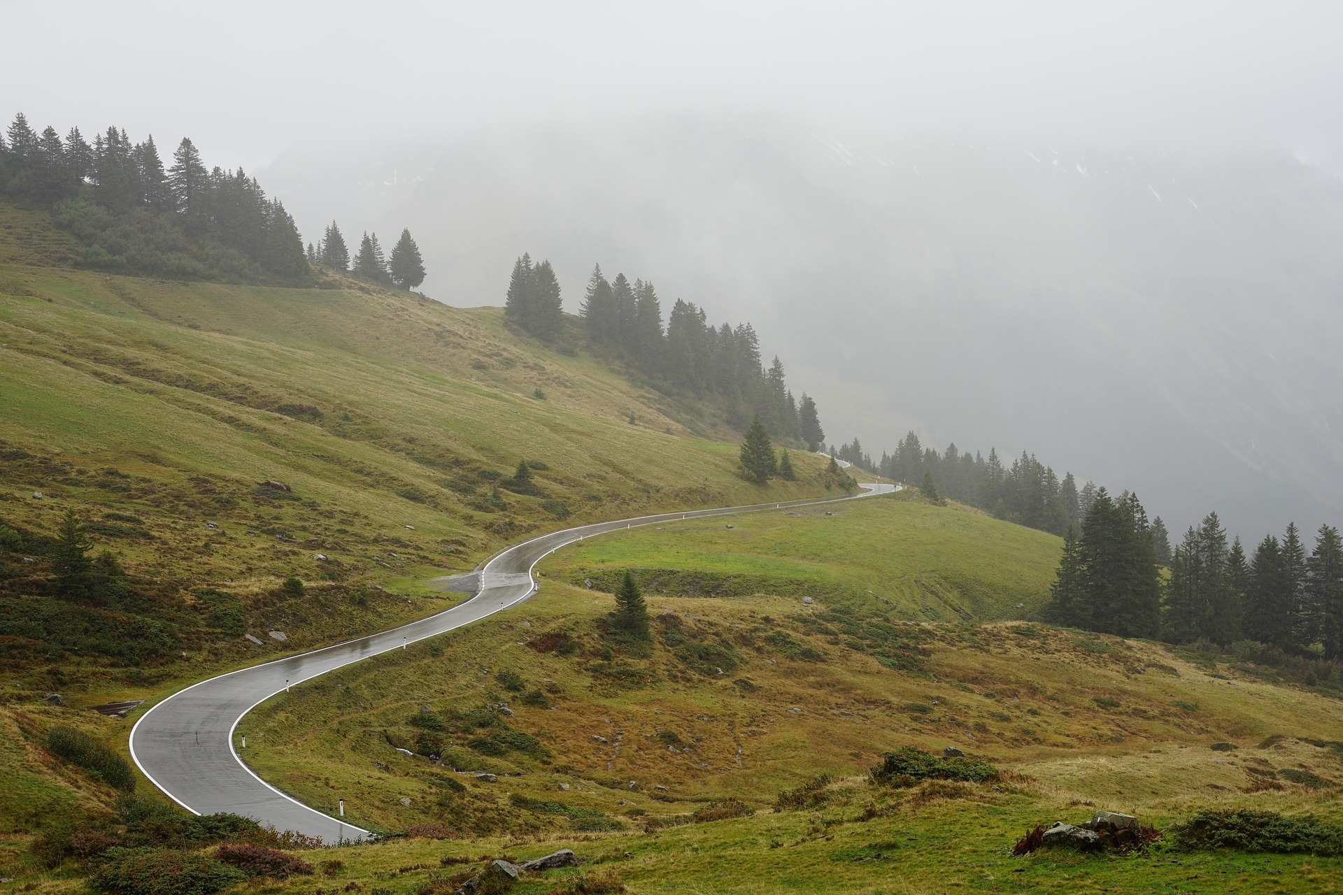 Route traversant le Val d'Izoard au milieu des alpages et des forêts dans les Hautes-Alpes.